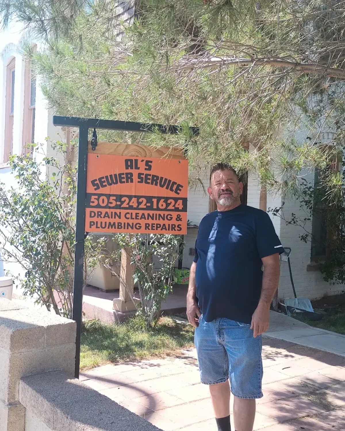 Al's Sewer Service Technician Al's Sewer Service technician standing by company sign